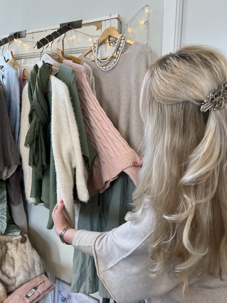 en kvinna står framför en klädställning